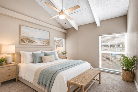 Virtually staged bedroom with a vaulted ceiling, exposed beams, large windows and coastal decor at Waterchase Apartments in Largo, FL.