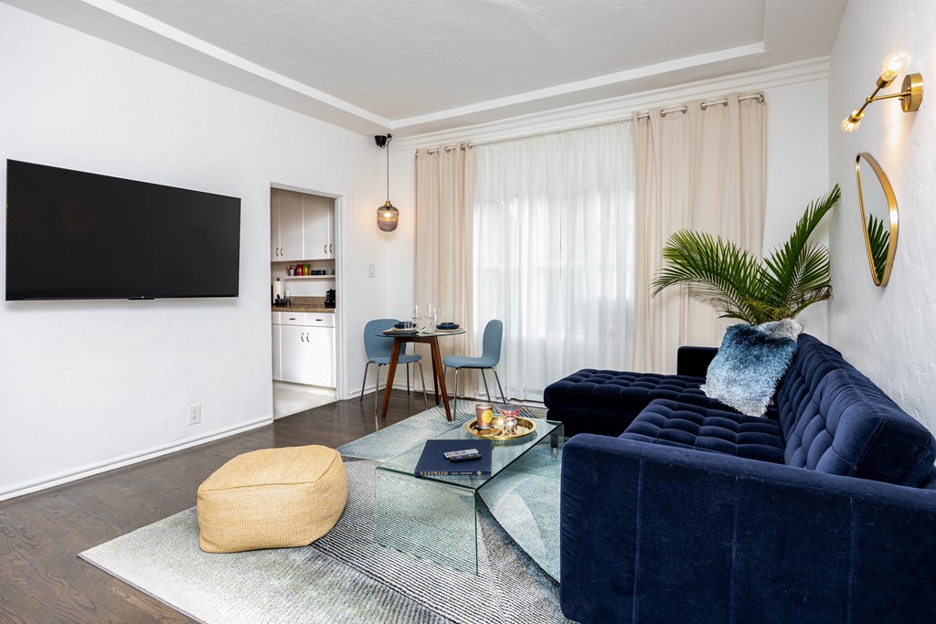 a living room with a blue couch and a glass coffee table