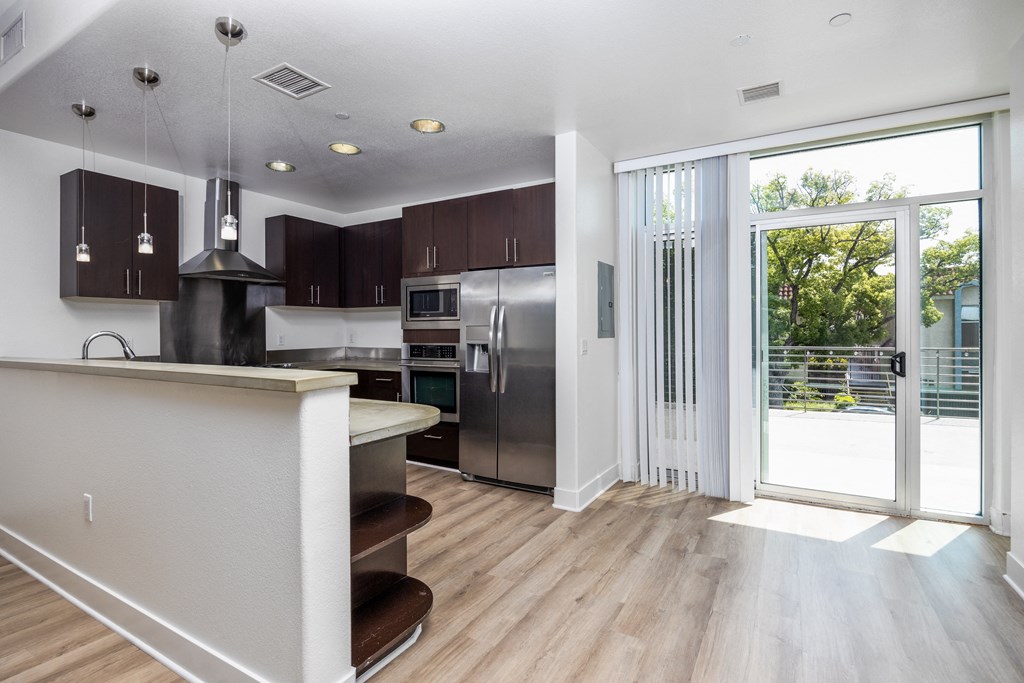 a kitchen with stainless steel appliances and a door to a patio
