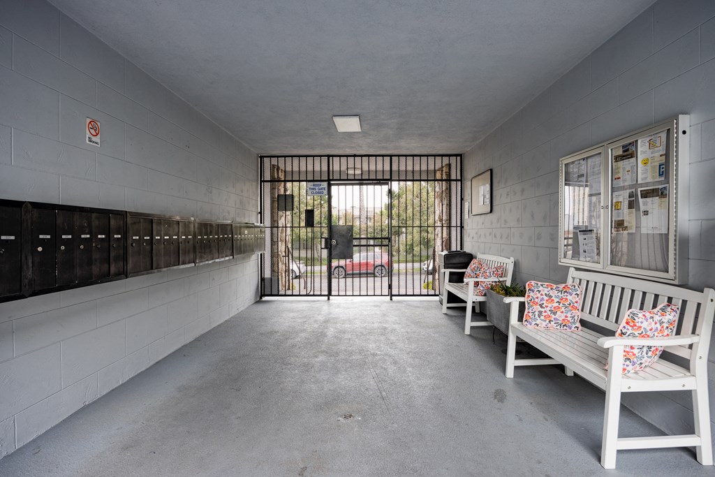 the lobby of a prison with benches and a gate