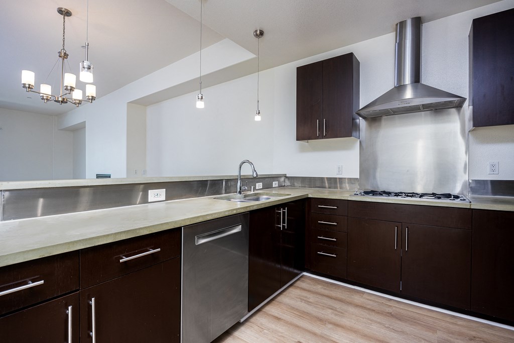 a large kitchen with stainless steel appliances and wood flooring