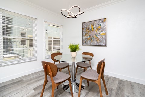 a dining room with a glass table and chairs and a ceiling fan