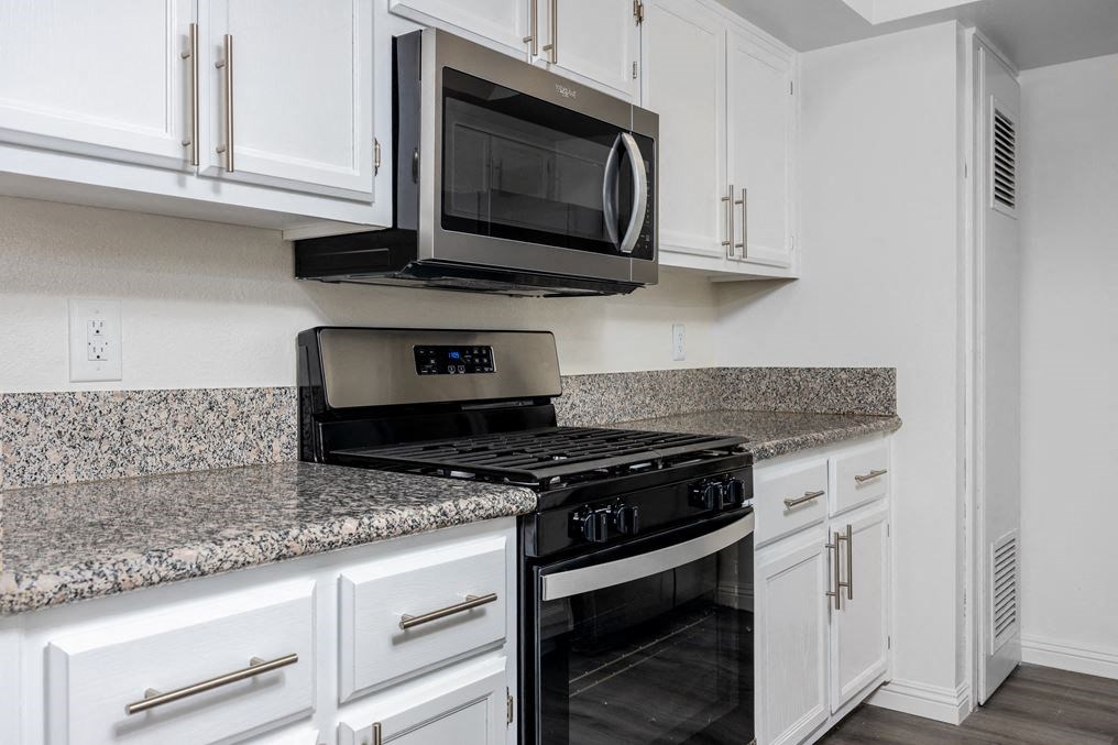 a kitchen with white cabinets and a black stove top oven