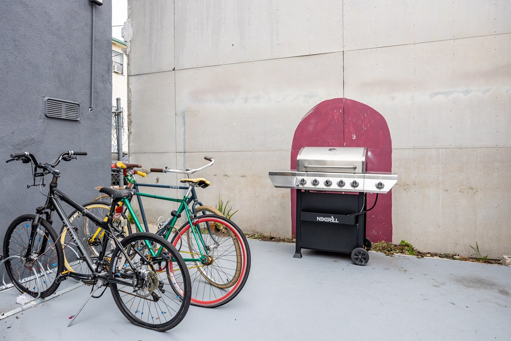 two bikes parked next to a wall with a grill