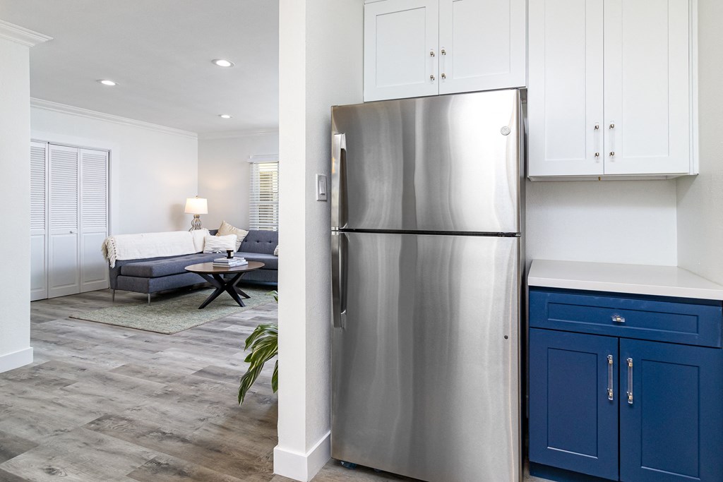 a kitchen with a stainless steel refrigerator and blue cabinets