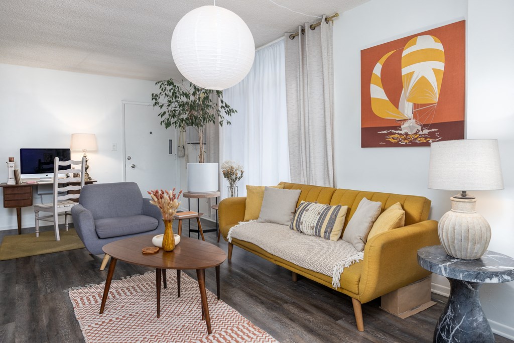 a living room with a yellow couch and a table