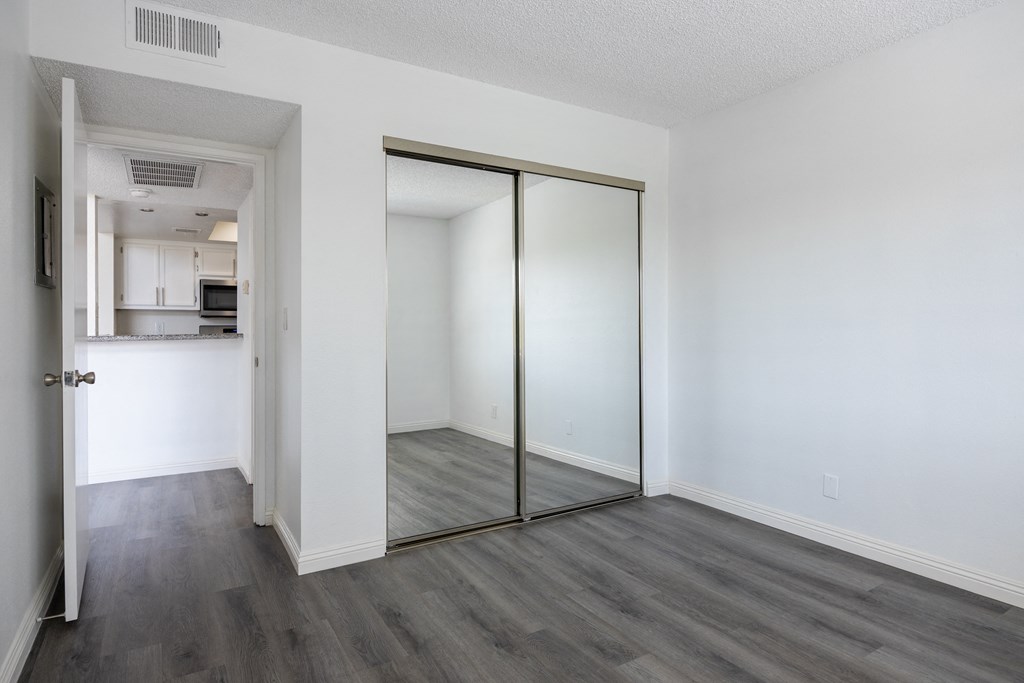 an empty living room with white walls and a sliding glass door