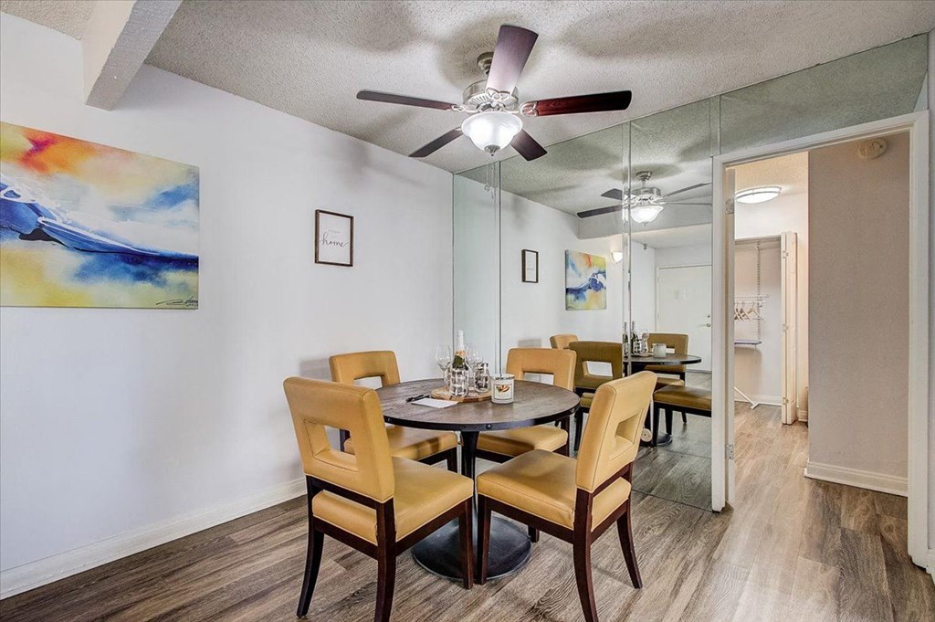 a dining room with a table and chairs and a ceiling fan