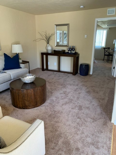 A living room with a white couch and a wooden coffee table.