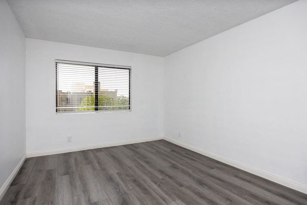 an empty room with a window and white walls