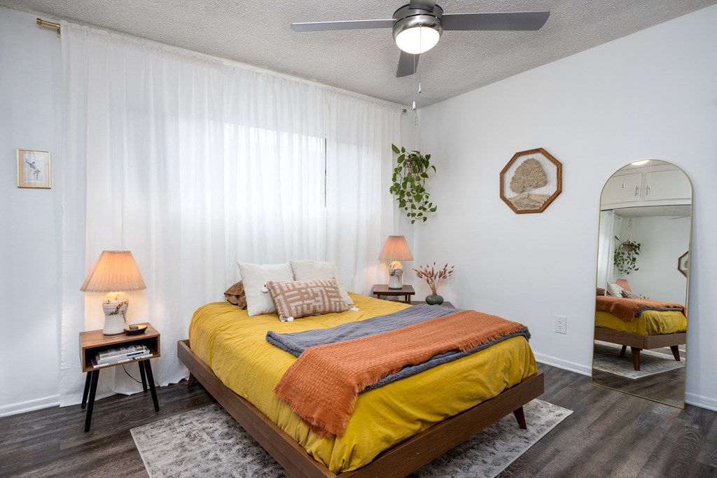 a bedroom with a yellow bed and a ceiling fan