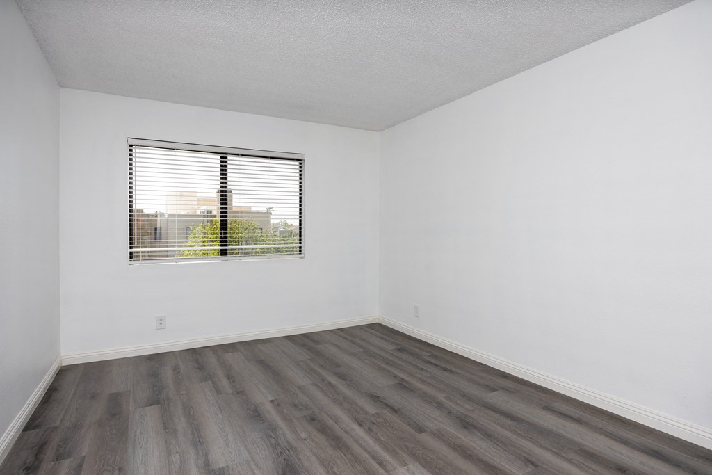 an empty room with white walls and a window