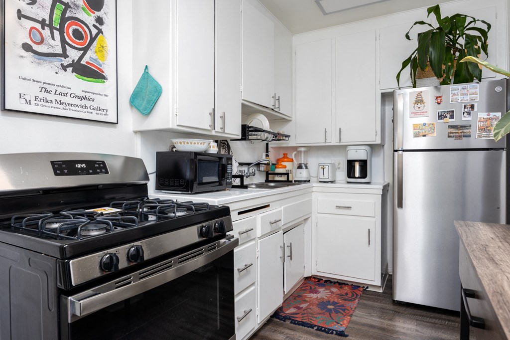 a kitchen with white cabinets and stainless steel appliances
