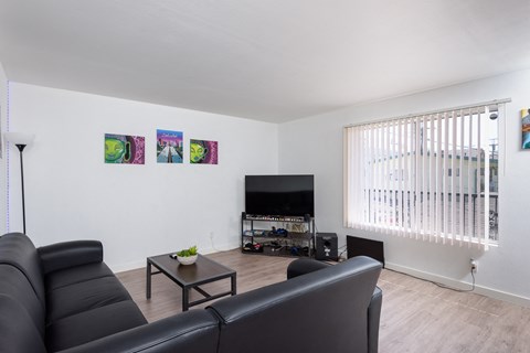 a living room with a black leather couch and a television