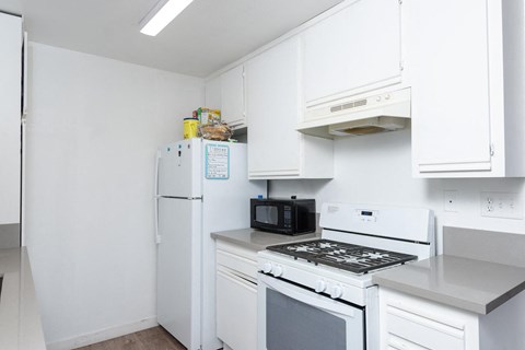 a kitchen with white cabinets and a stove and refrigerator