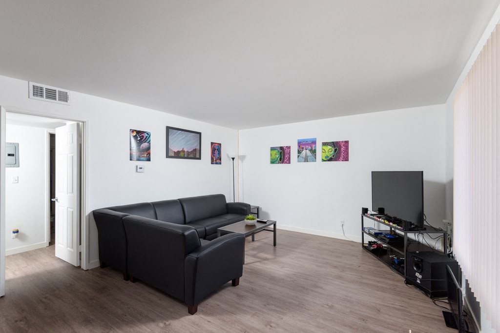 a living room with white walls and a black couch