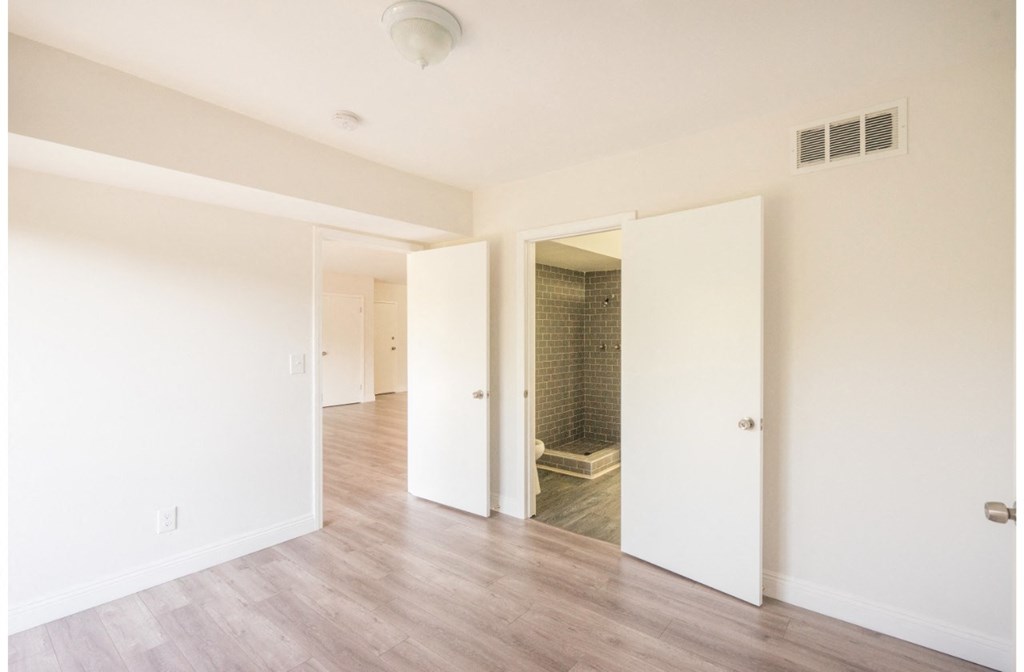 an empty living room with white walls and a walk in shower