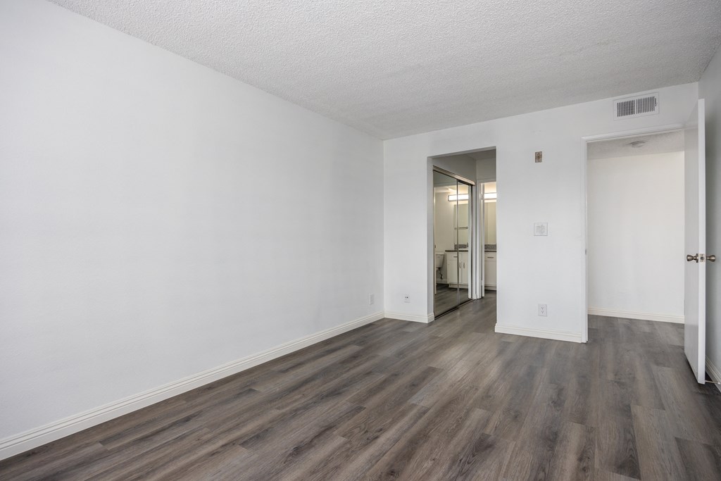 an empty living room with white walls and wood flooring