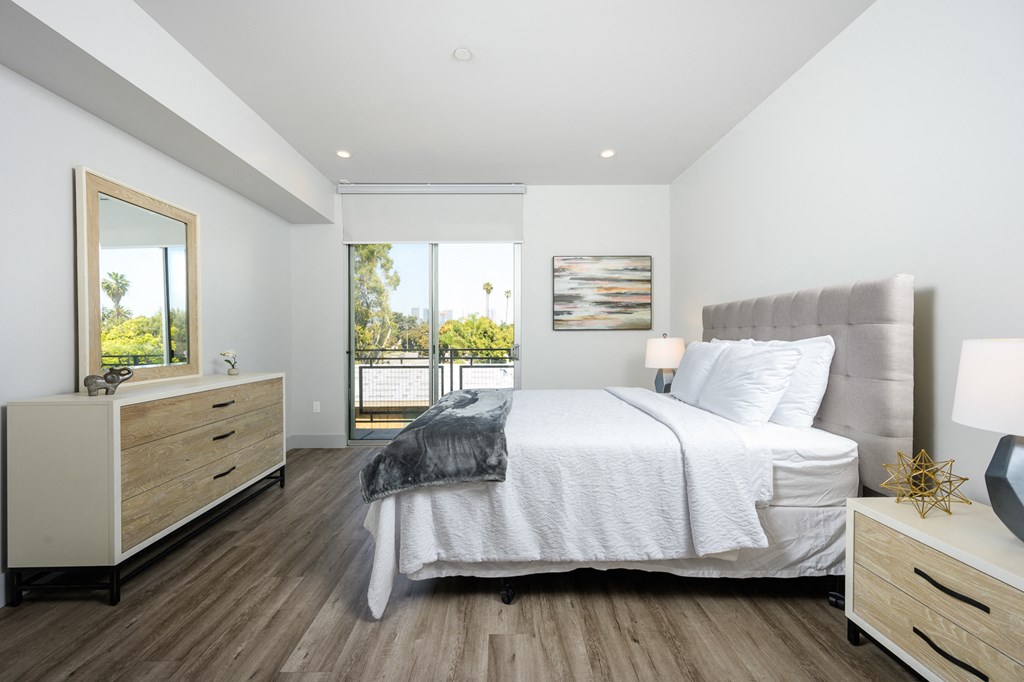 a white bedroom with a bed and a large window