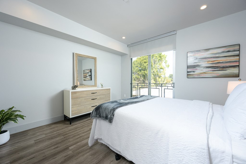 a bedroom with a bed and a dresser and a window