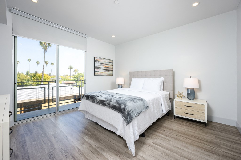 a bedroom with a bed and a door to a balcony
