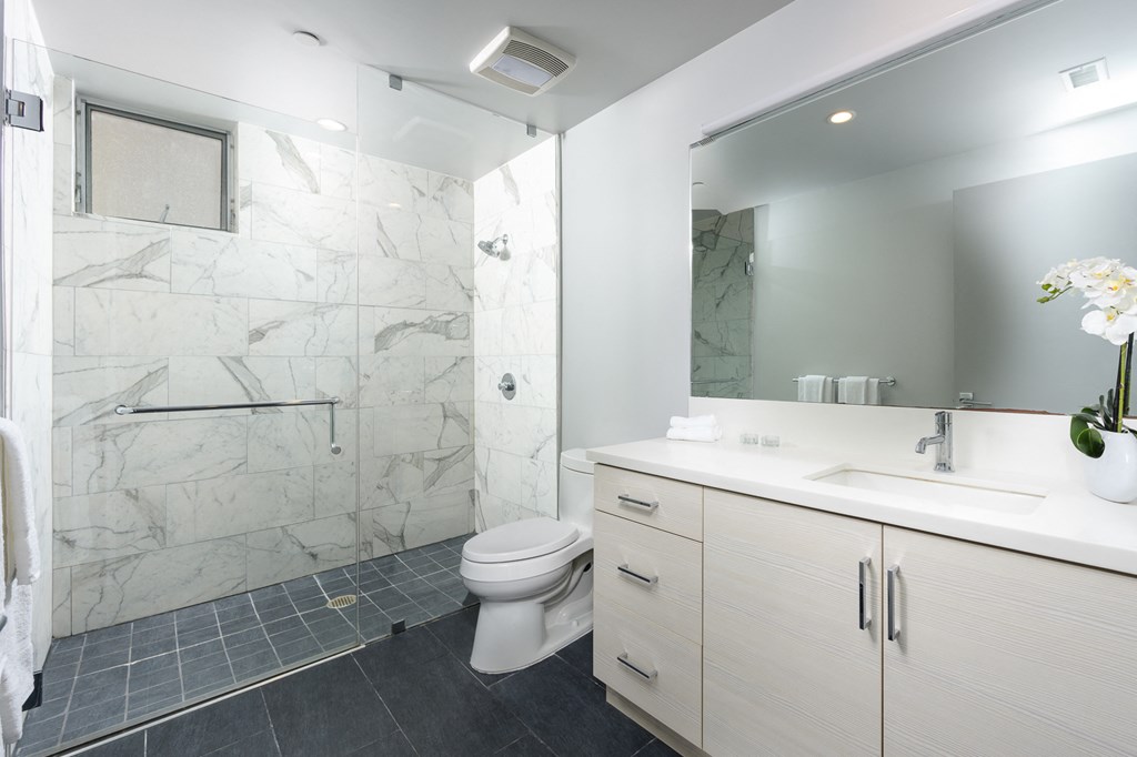 a bathroom with a shower and a sink and a toilet