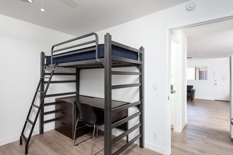 a bedroom with a bunk bed and desk in a 555 waverly unit