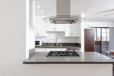 a kitchen with white cabinets and a black counter top