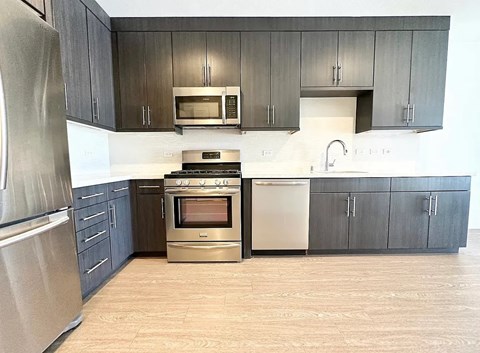 A kitchen with a stainless steel refrigerator and a stainless steel oven.