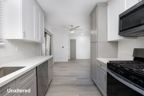 A kitchen with white cabinets and a black stove top oven.