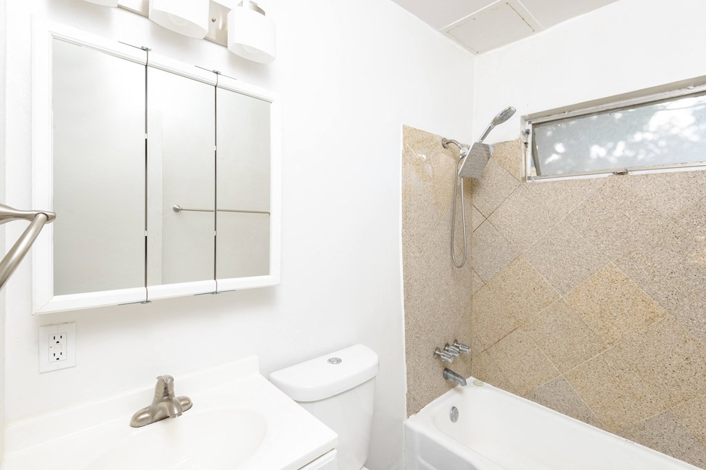 a bathroom with a white sink and tub and a white toilet