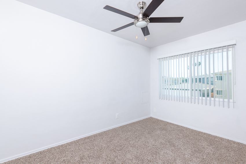 a bedroom with a ceiling fan and window - Photo Gallery