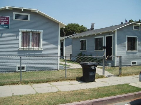 A small grey house with a sign that says "Property Management" on it.