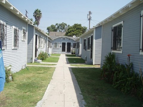 A row of houses with a sidewalk in between.
