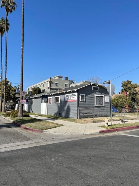 A grey house with a "For Rent" sign on the front.
