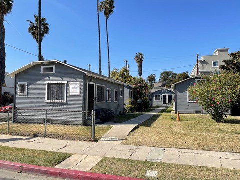 A grey house with a red curb in front of it.