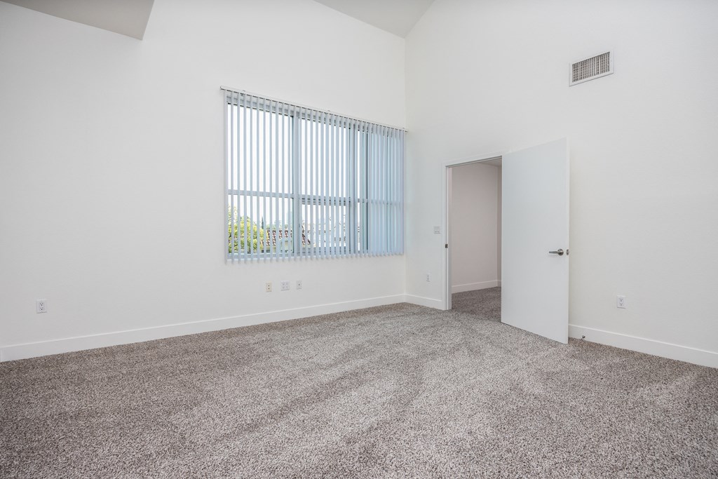 an empty living room with carpet and a window