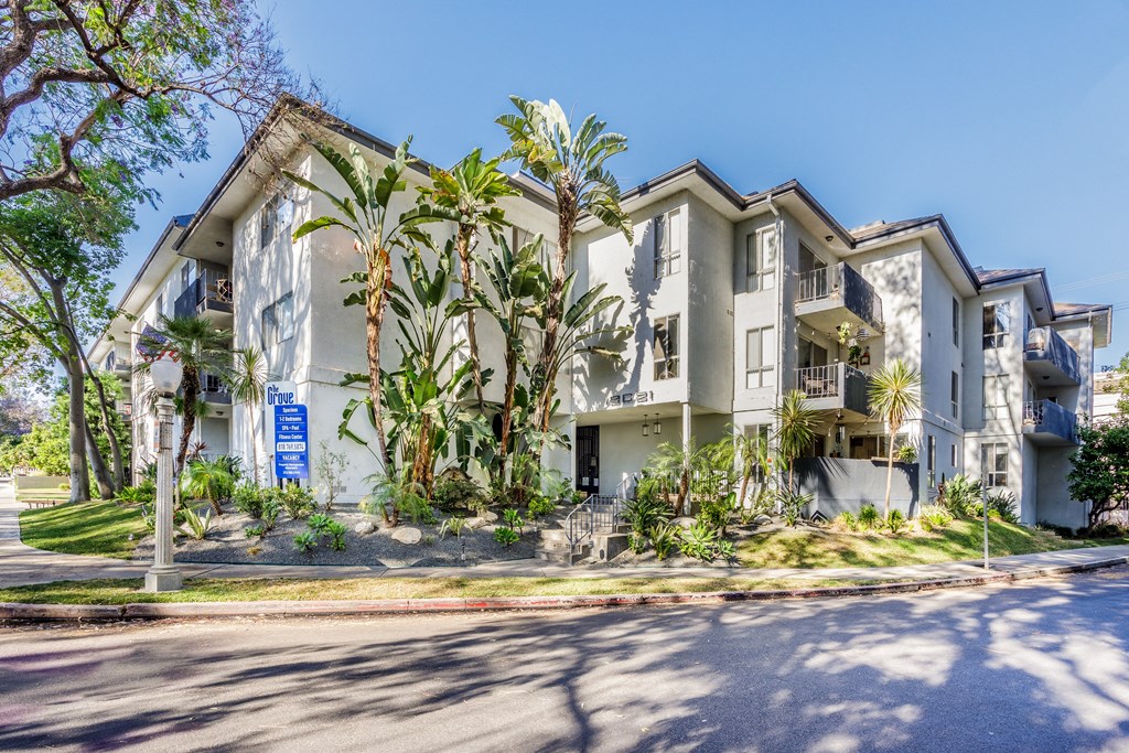 a large apartment building with palm trees in front of it