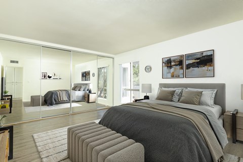 A bedroom with a large bed and a mirrored wall.
