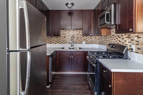 a kitchen with stainless steel appliances and wooden cabinets