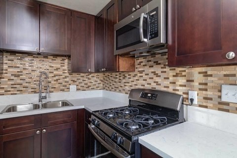 a kitchen with a stove and a sink and a microwave