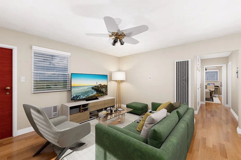 A living room with a green couch and a television.