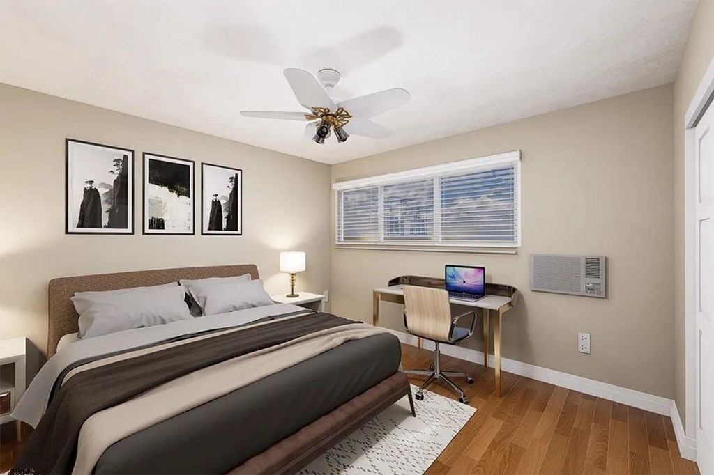 A bedroom with a bed, desk, and chair.