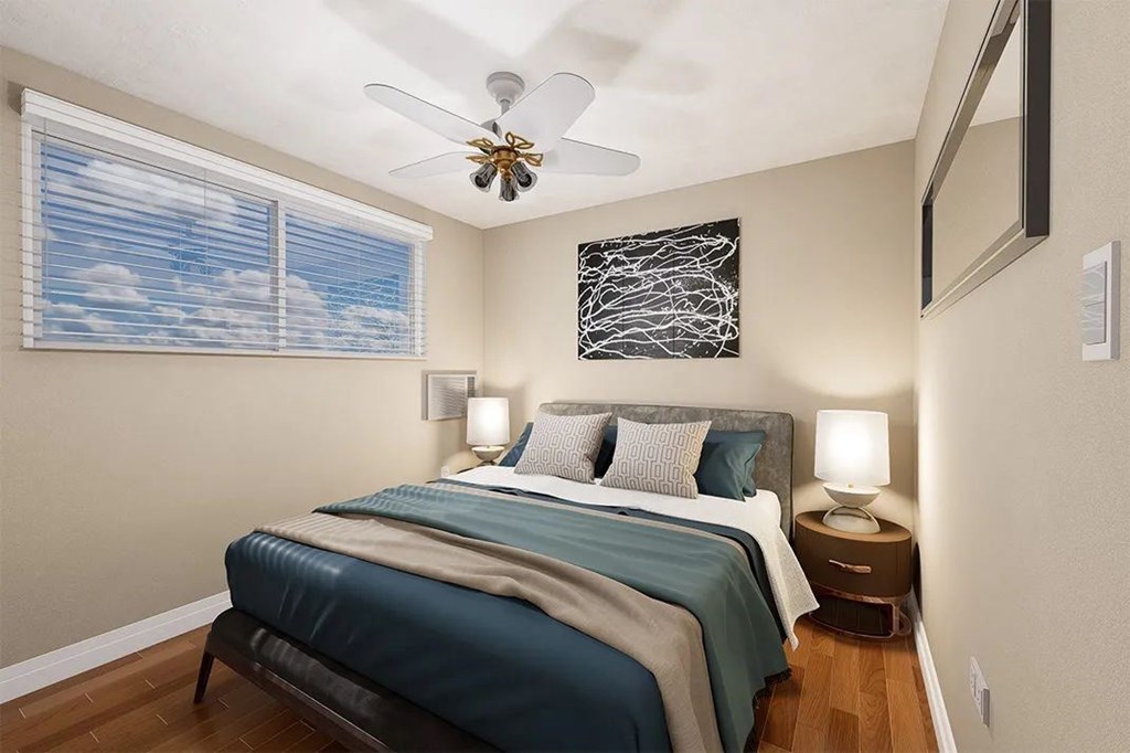 A bedroom with a bed, a ceiling fan, and a window with blinds.