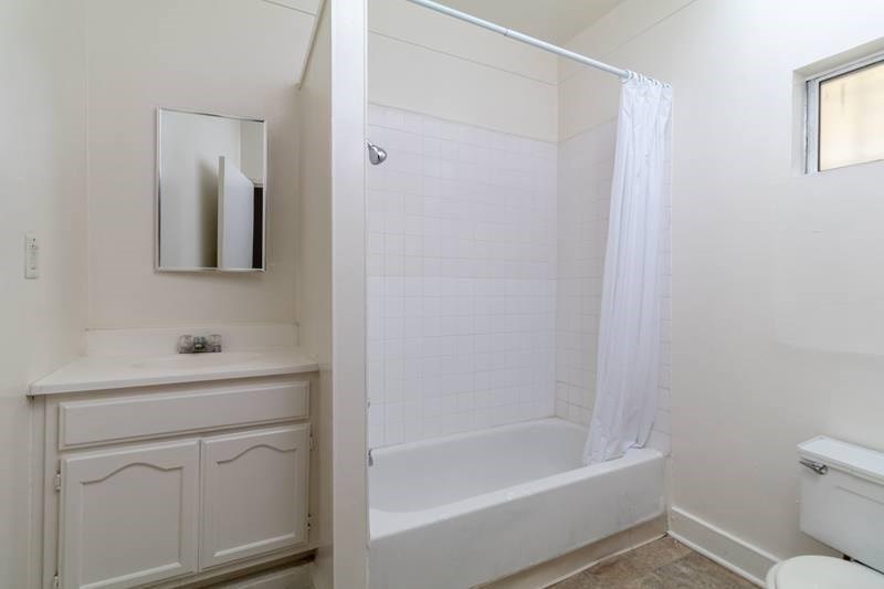 A white bathroom with a tub, sink, and toilet.
