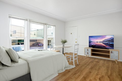a bedroom with a bed and a desk and a tv