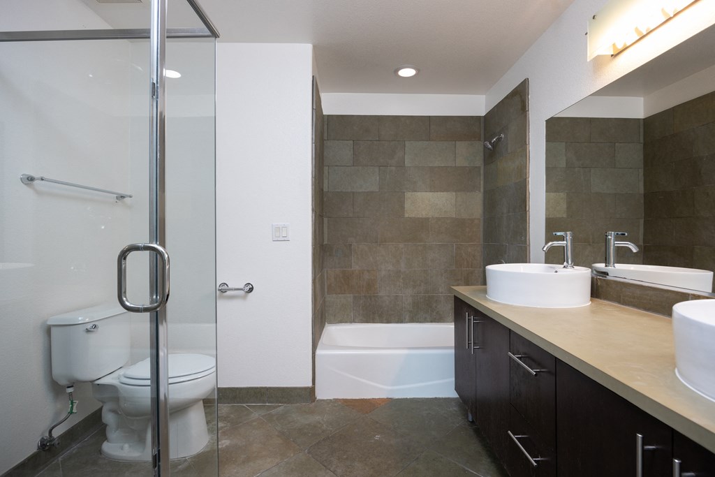 a bathroom with a toilet and a shower and a sink