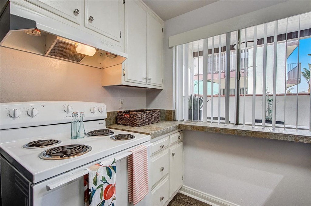 a kitchen with a stove top oven next to a window
