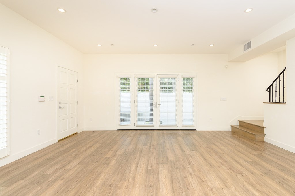 a living room with a hard wood floor and a staircase