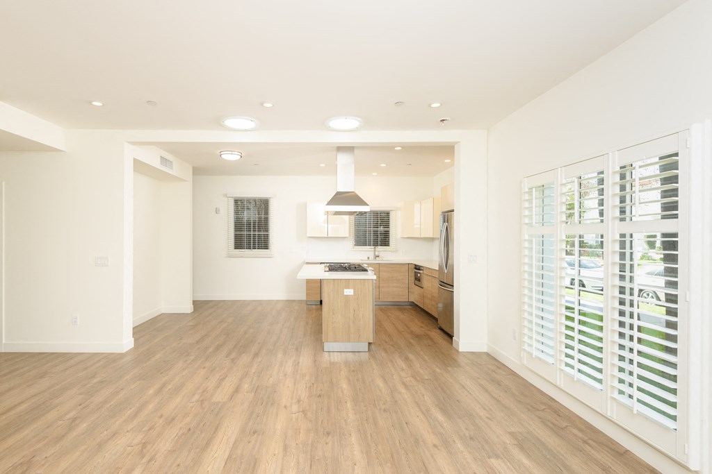 a large kitchen with white walls and wood floors and a large island
